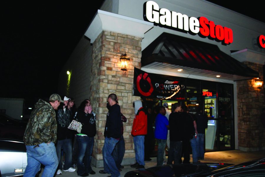 (Above) Dedicated ‘Call of Duty’ fans assemble outside GameStop at midnight. ‘Call of Duty: Black Ops’ sold 5.7 million copies in the first day. (Below) UNA junior Kyle Thomas proudly hoists his copy of ‘Black Ops.’ Thomas was one of millions nationwide to pre-order a copy.

