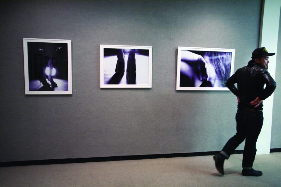 Student photographer Keisuke Banzashi displays pictures he took at the art exhibit held at the University Art Gallery. 