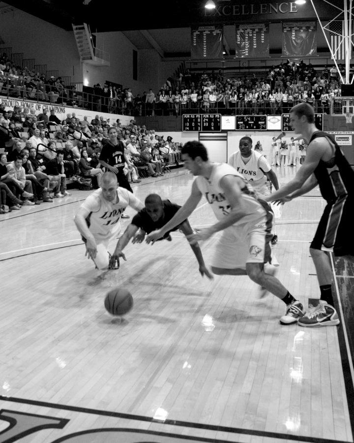 UNA players Wes Long and Sam Buxton dive at a loose ball to try to keep it from a UAH player in a game against the Chargers earlier this season. The Lions lost a close contest but still made the GSC Tournament.