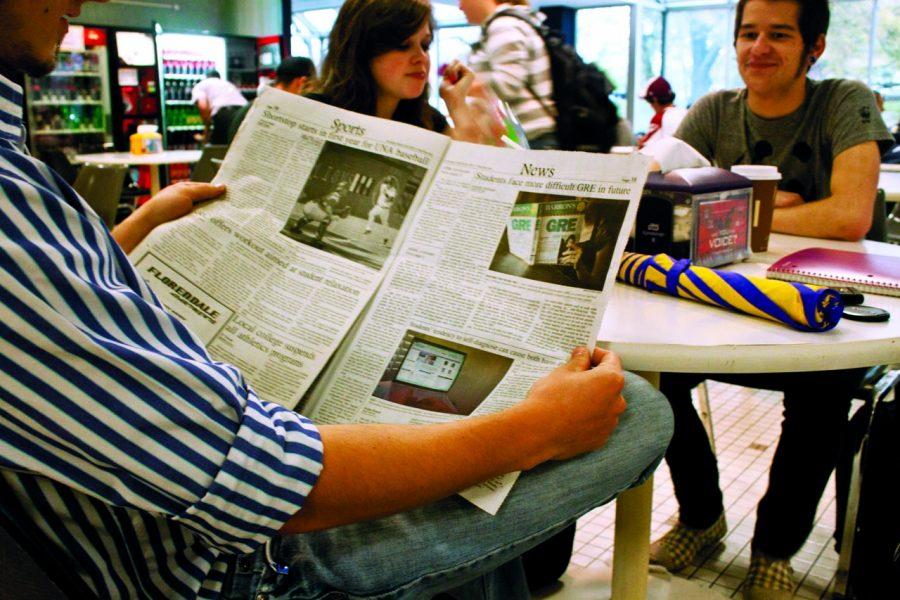 Students read the news in the GUC Atrium. Reports find that more people are giving up newspapers for television news when seeking information about international issues.