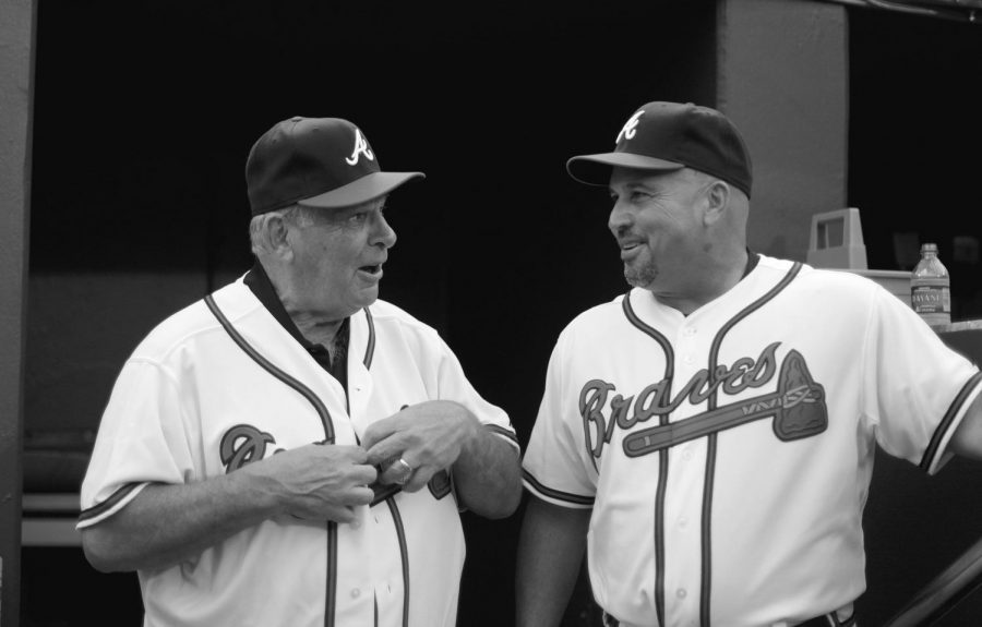 Former Atlanta Braves manager Bobby Cox, left, puts on a team jersey before throwing out the first pitch to current Braves manager Fredi Gonzalez, right, at the Braves home opening day baseball game against the Philadelphia Phillies Friday, April 8, 2011 in Atlanta.