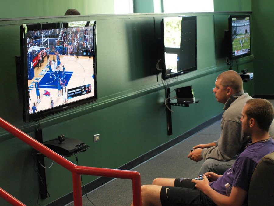 Two UNA students play video games in the Lions Den