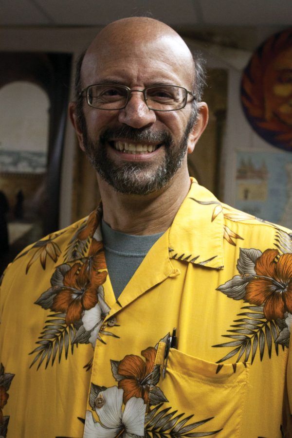 Dr. Robert Adler stands in his office sporting his trademark
Hawaiian-themed button-up shirt.
