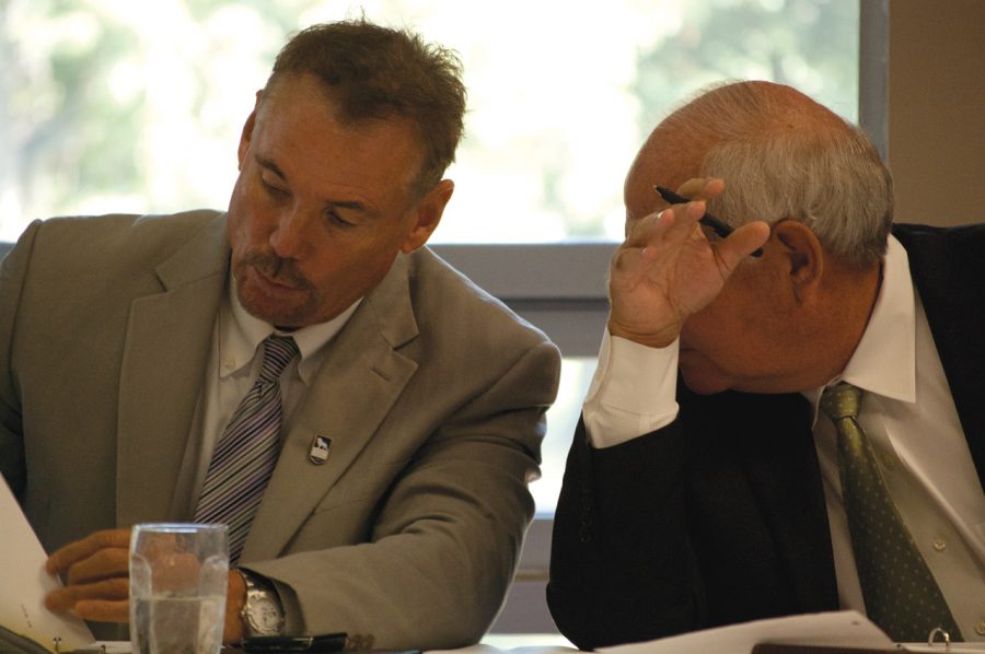 Board of trustees members Steve Pierce and Rodney Howard have a conversation during the Sept. 15, 2011 board meeting. 
