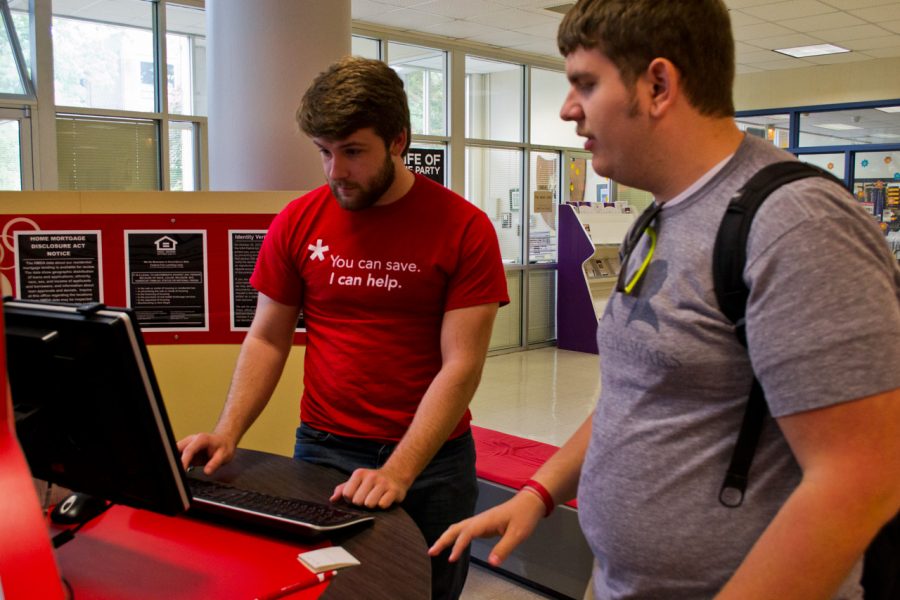 The Hill student employee Trent Cronin assists a student at The Hill location in the Guillot University Center. 
