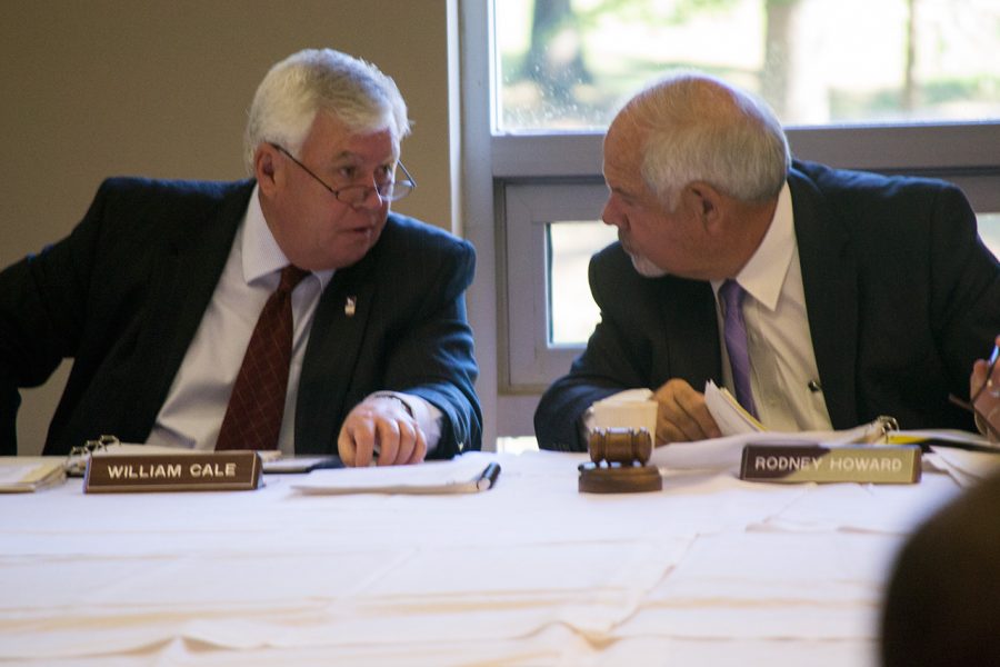 UNA President Bill Cale speaks with board President Rodney Howard during Monday's board meeting.
