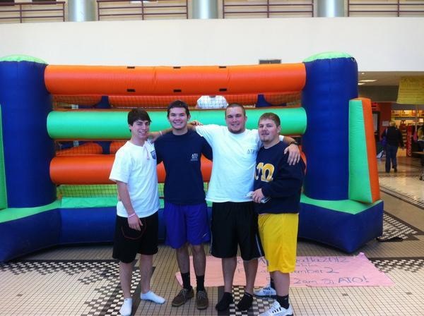 Scott Hawkins, Will Britton, Jason Zak and Jacob Winkles pose outside of the bouncy castle where they recently broke the world record for consecutive hours in a bouncy castle. 
