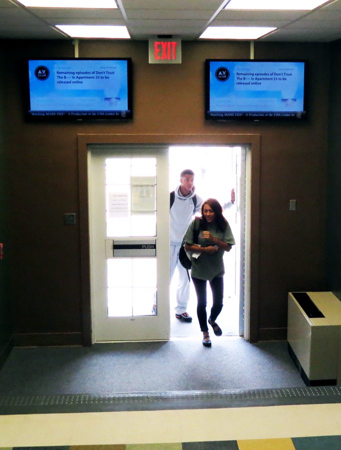 Students enter Keller Hall beneath two new MANE Feed screens to be located in various buildings on campus. Keller Hall houses six of the screens, which were obtained by the College of Business through a $100,000 grant.
