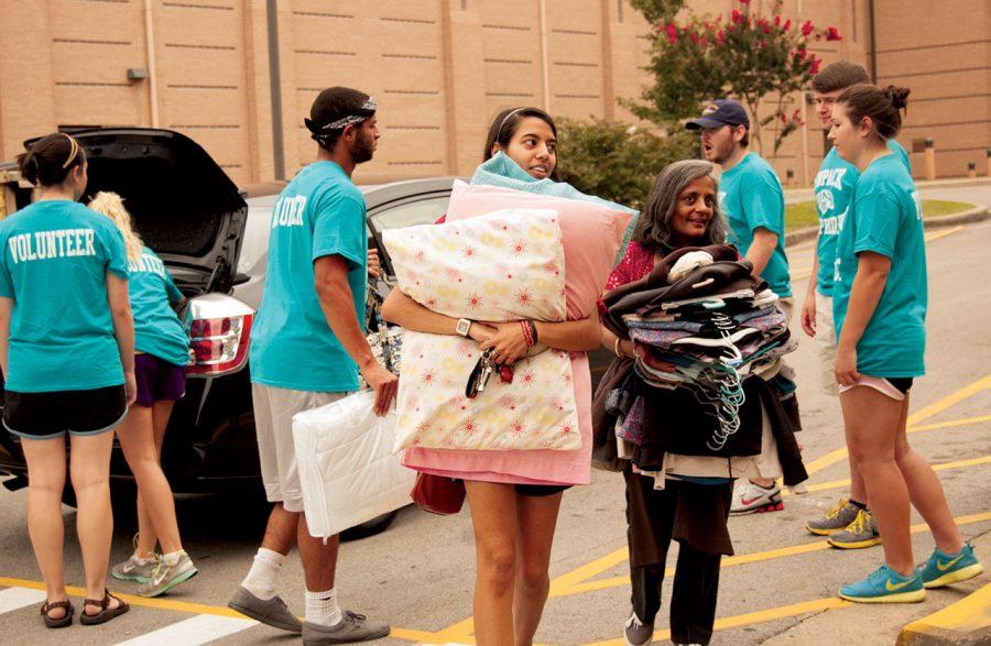 Freshman Christina Garrick carries her belongings into LaGrange Hall with the help of ‘Unpack the Pride’ volunteers. Volunteers included students, parents and campus faculty and staff.