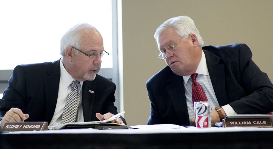 Board of Trustees Executive Committee Chair Rodney Howard discusses the agenda with President Cale during the December 2013 Board of Trustees meeting.