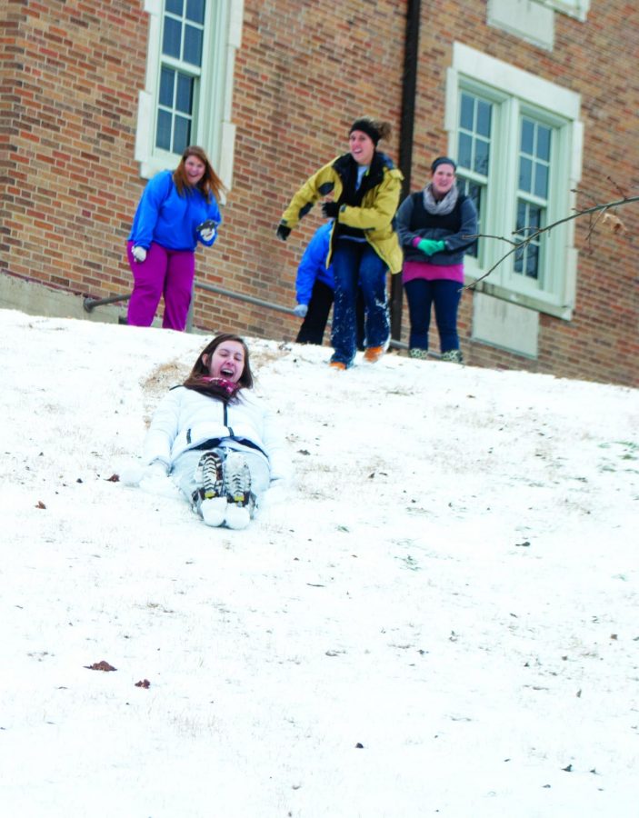 McKenzie Burns sleds down the hill in front of Powers Hall while Tiffani-Paige Avery, Rachel Terry, Alyson Mavromat and Christina Caufield look on during the Feb. 11 snow day.