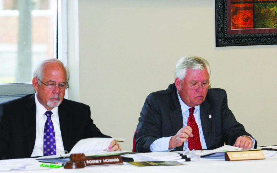 Rodney Howard and William Cale review charts during the March 17 Board of Trustees meeting.