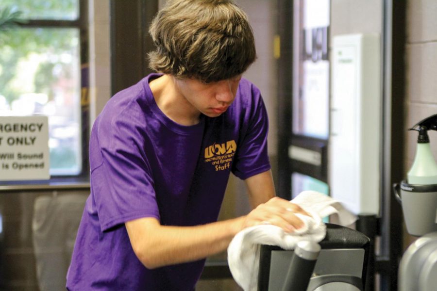 Milton Bain, a student worker in the Student Recreation Center cleans equipment for student use. Many students said it is not fair for all student workers to be paid the same, as some of them have more strenuous jobs.