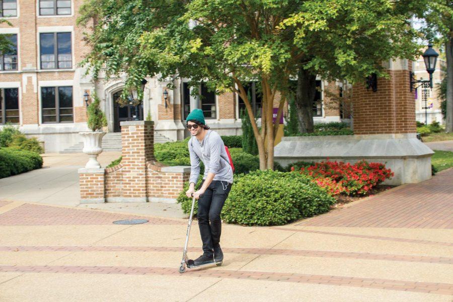 Junior Will Martin rides his scooter across campus between classes. Martin said students can save time and gas by using alternate modes of transportation to get to school.