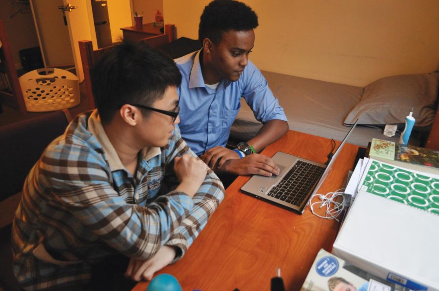 Osman Ahmed (right), of Kenya, and Yiming Wang, of China, watch a video on Ahmed’s computer. Ahmed and Wang have few problems sharing their room in Covington Hall despite their cultural differences.