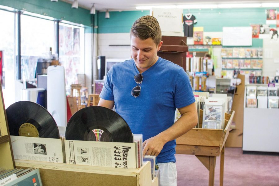 Student Ryan Ferrara looks through the selection of vinyl available at Pegasus Records in downtown Florence. Records have seen an increase in sales this year, according to Nielsen.