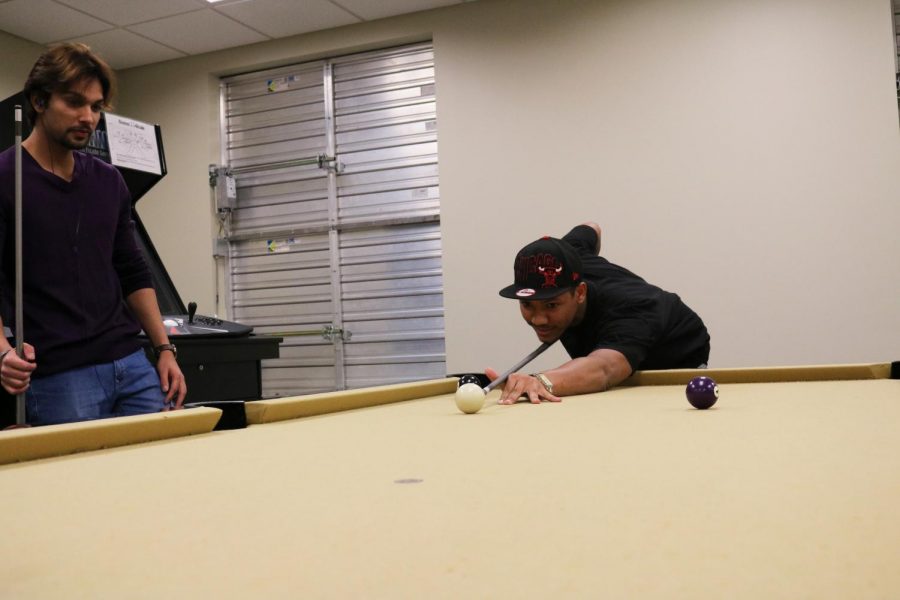 Junior Sumit Kapoor (left) and freshman Tyrone Yarbrough shoot pool in the common area of Olive Hall Jan. 19. Residents enjoy spacious common areas, free cable television access, video games and Wi-Fi in the residence halls.