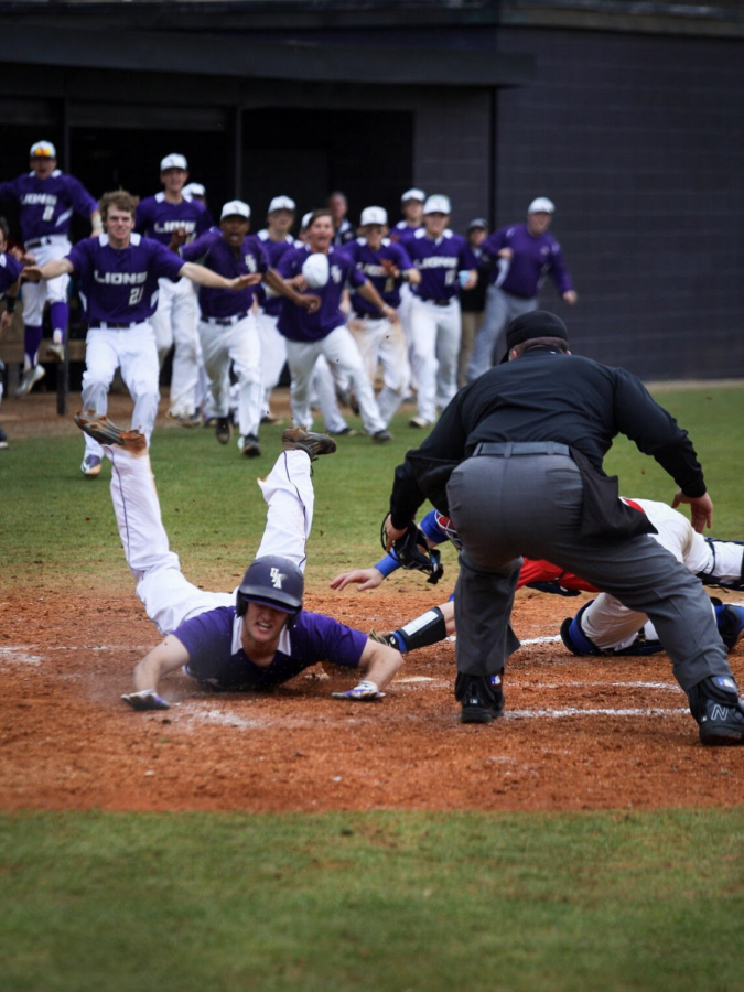 Senior right fielder Dylan Calhoun slides into home to score the winning run against West Georgia Feb. 20. The Lions took the series 2-1 after splitting a double-header Feb. 19.