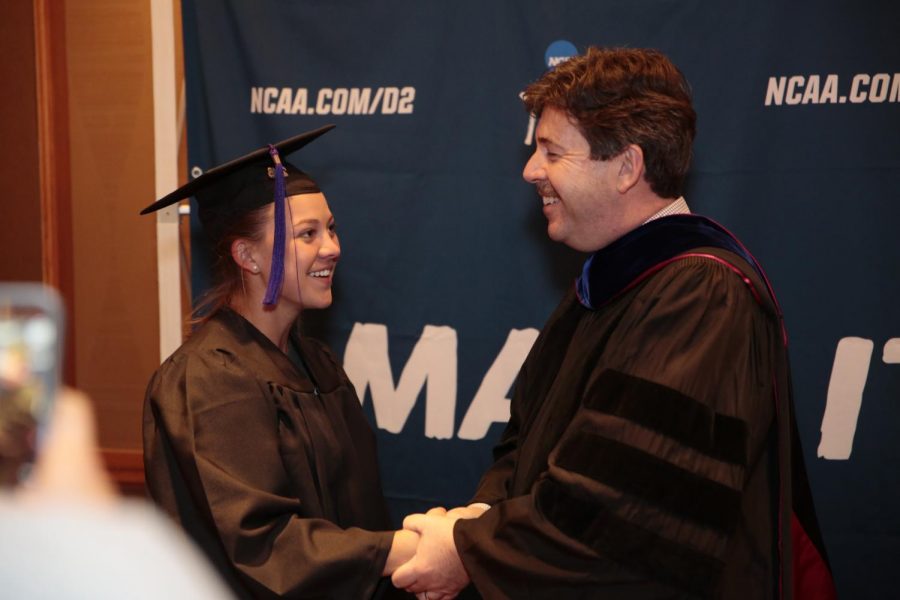 Graduating senior Harlie Barkley accepts her diploma from University President Kenneth Kitts at the Sheraton Denver Downtown Hotel May 21. Barkley, a member of the UNA softball team, missed the graduation ceremonies May 14 as she was traveling for the Division II Softball Championships in Denver.