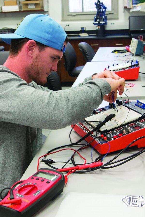 Junior Ben Ragan measures voltage in an experiment in an engineering technology class. The Engineering Technology Department received a grant to add a Chemical Engineering Technology program.