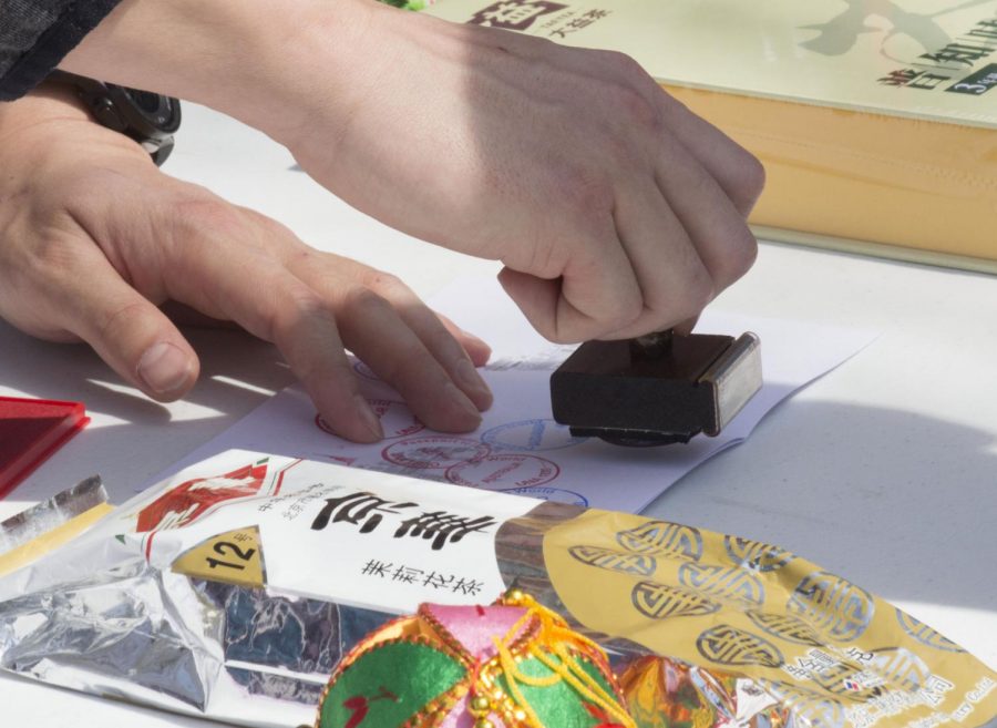 An international student stamps a Kilby students passport during the Office of International Affairs Passport to the World. The biannual event allows international students to represent their home countries culture.