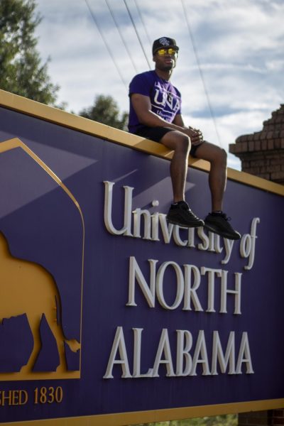 Leo Whyte sits atop the UNA sign.