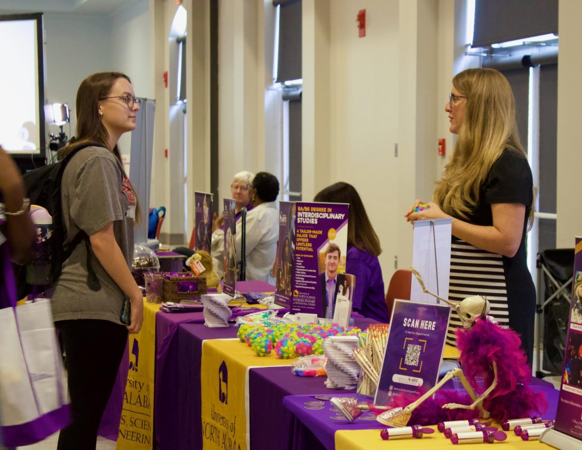 An Interdisciplinary studies faculty member talks to an interested student. 