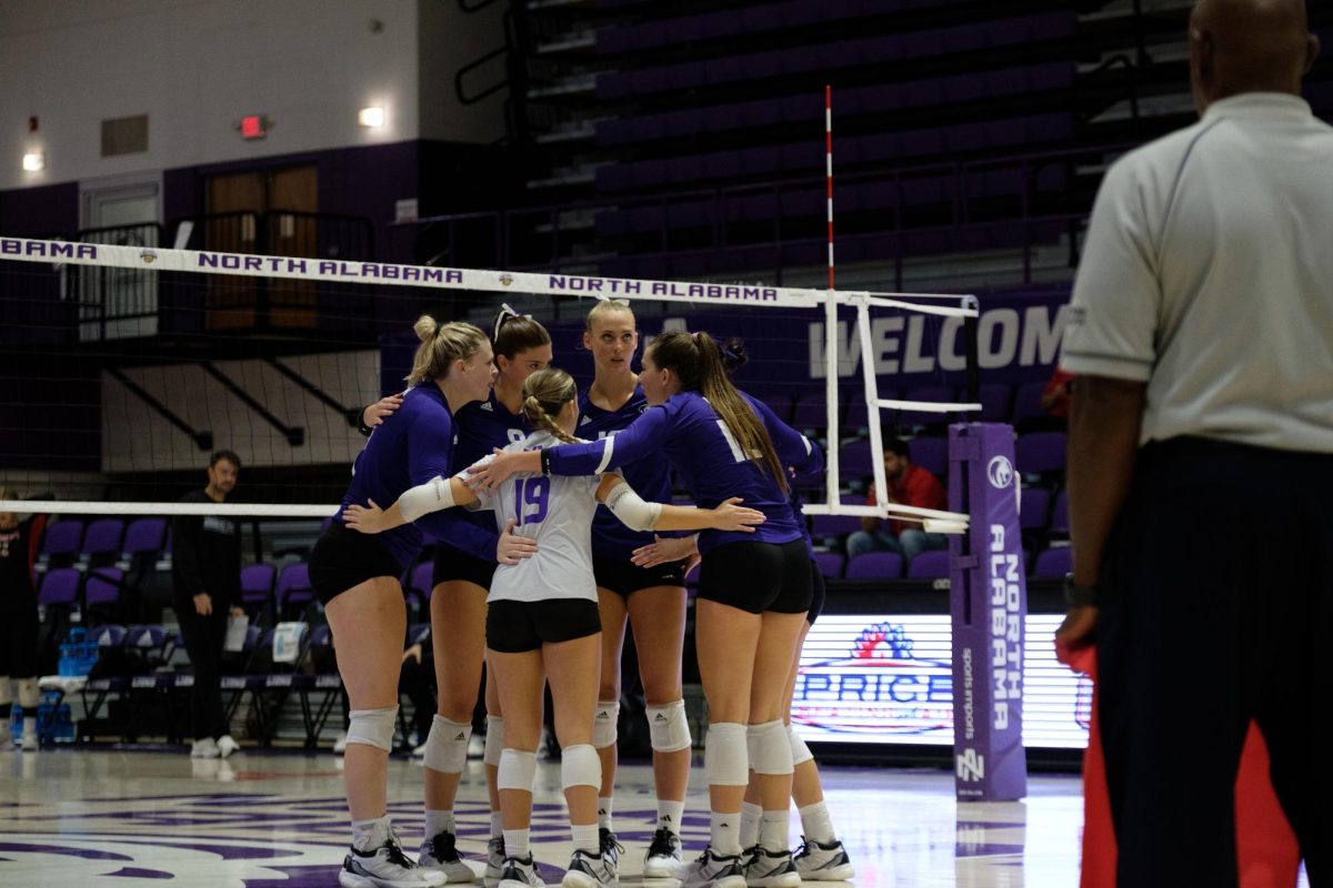 Volleyball players huddle to discuss strategy.