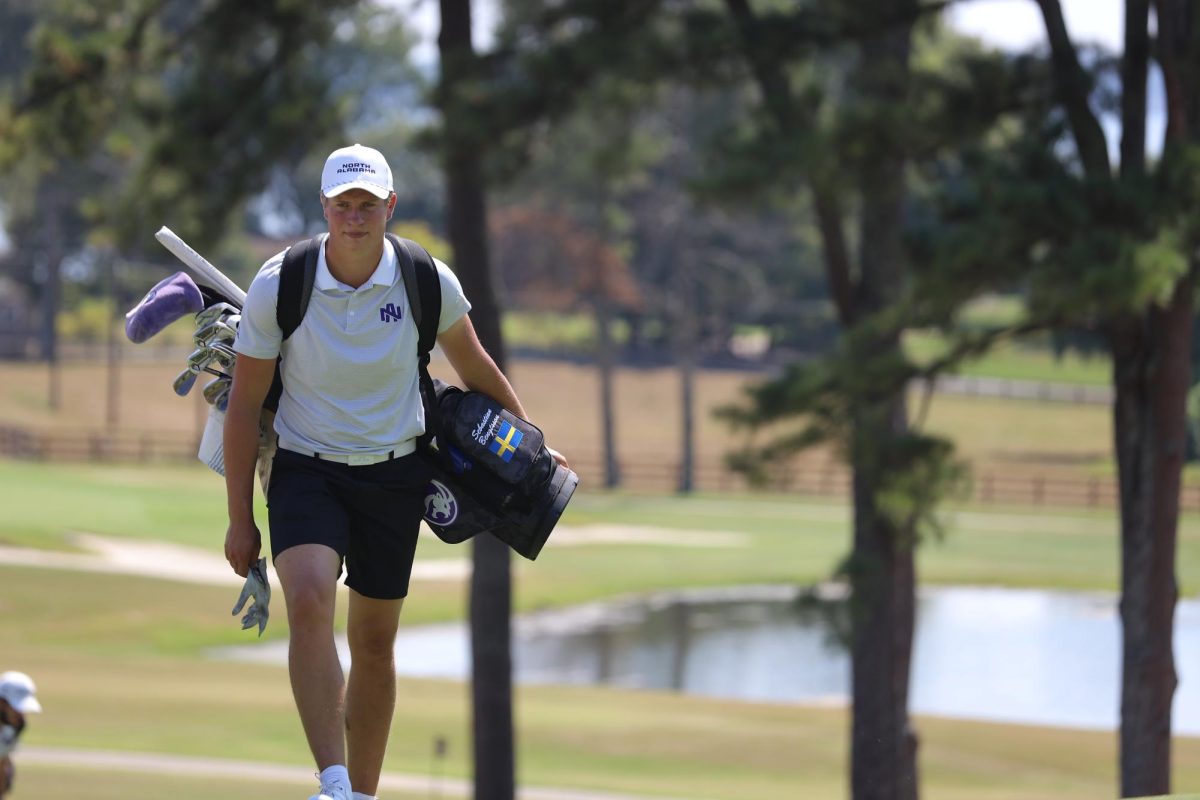 COURTESY OF UNA ATHLETICS | Sebastian Bengtsson carries his golf bag in a tournament. 