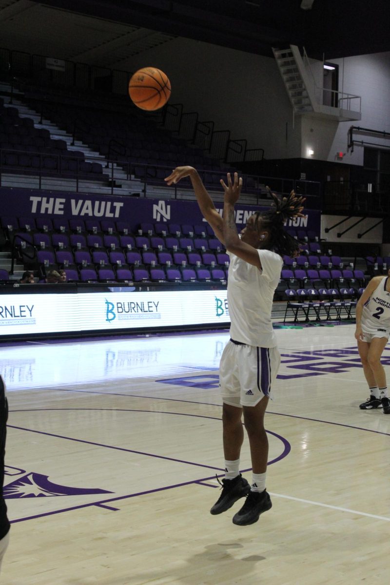 Basketball player performs jump shot.