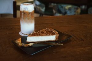 Jaizon's biscoff cheesecake and a salted caramel latte on a table.